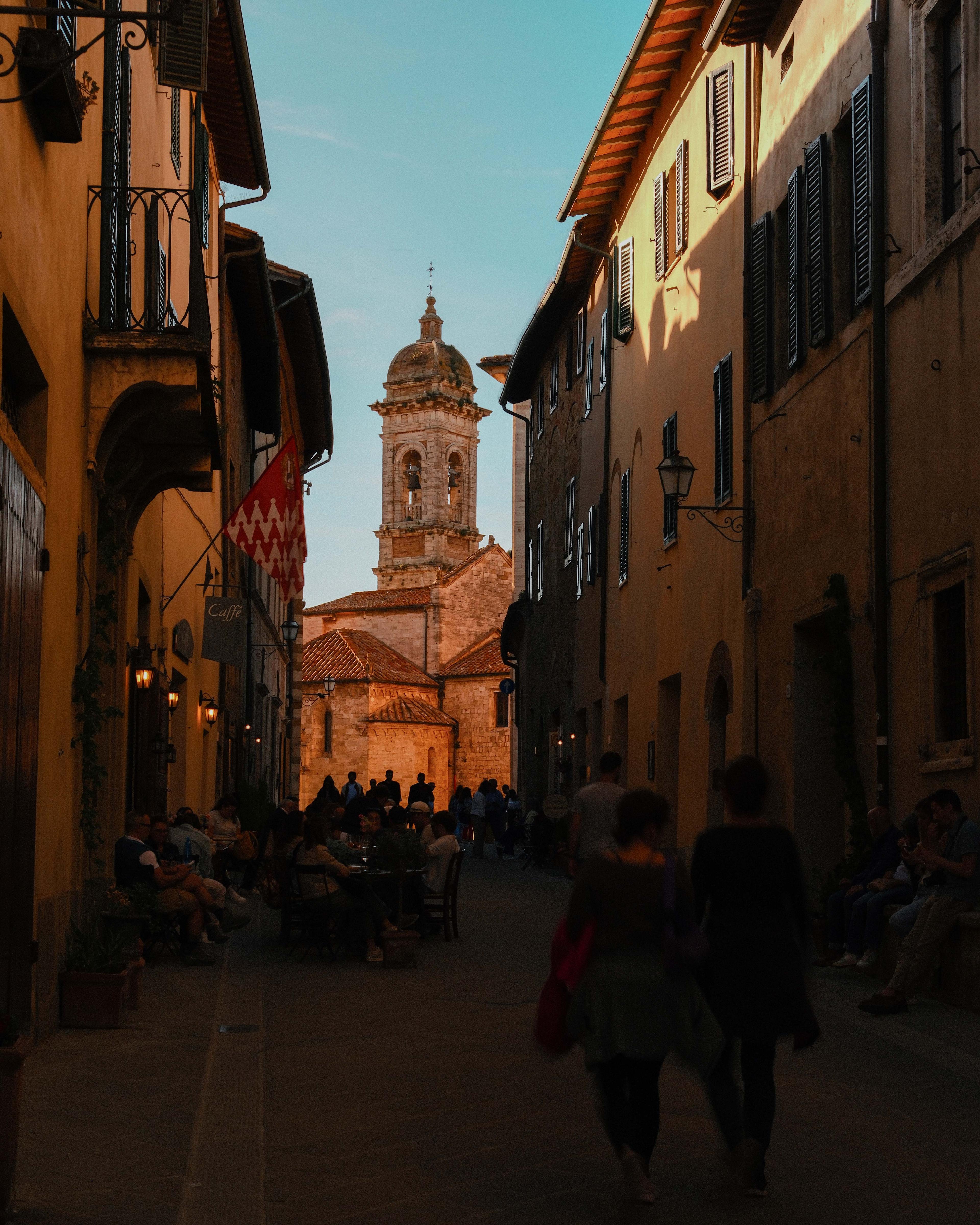 People gathered along an evening street in Siena.