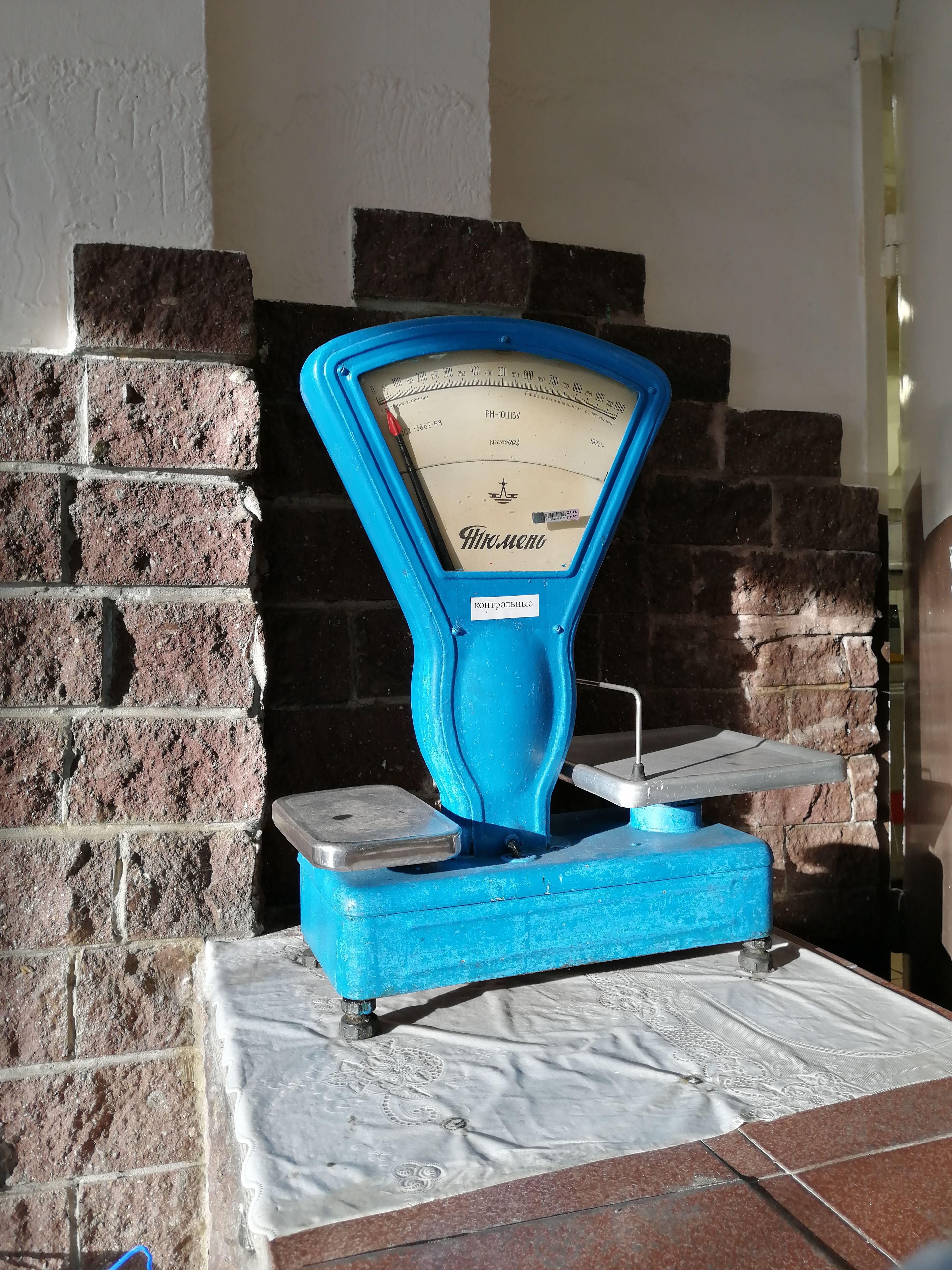 A vintage blue weighing scale in warm natural light.